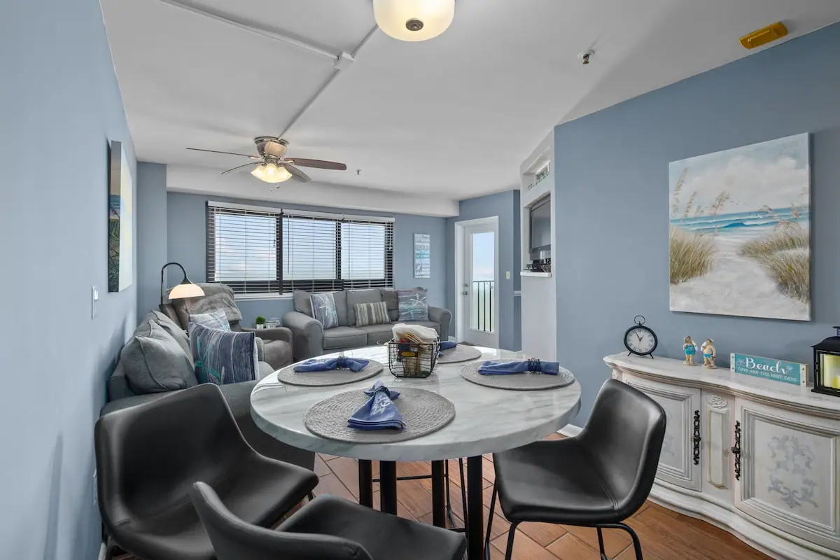 Living and dining area with blue walls, a round table, and a sofa
