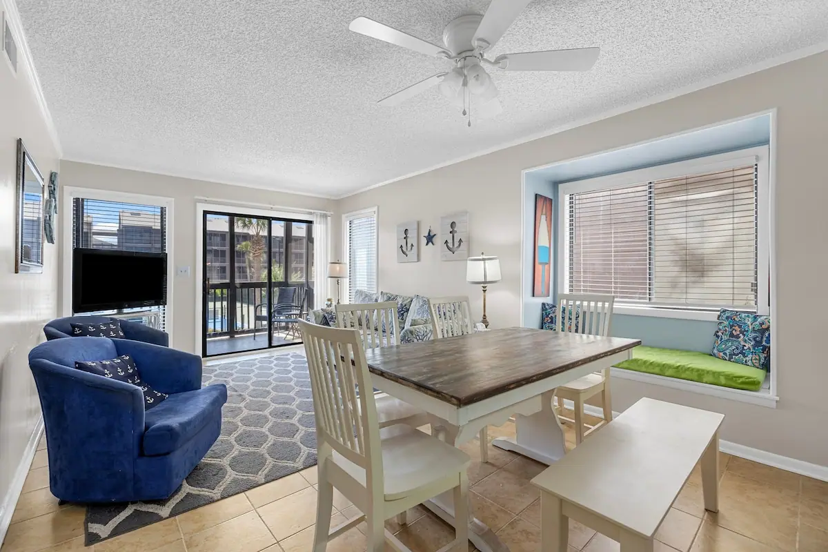 Living and dining area with a window seat and sliding balcony doors