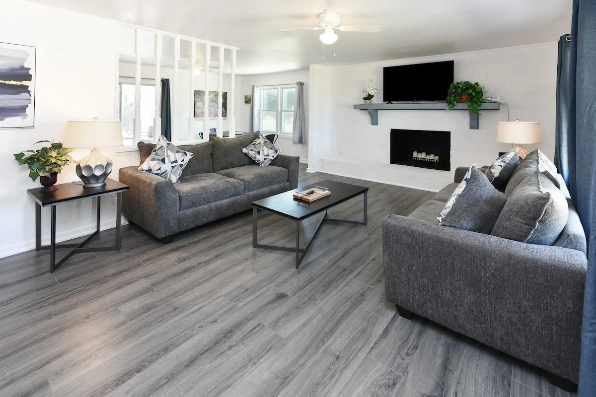 Living room with gray sofas, a television, and an electric fireplace
