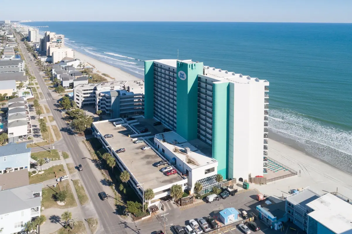 Aerial view of beachfront buildings, the sandy shore, and the ocean