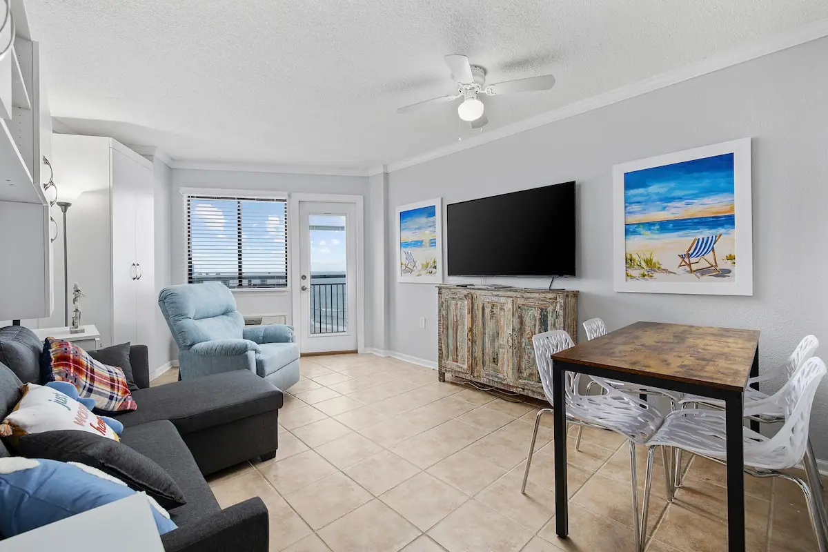 Living room with a recliner, television, and balcony door