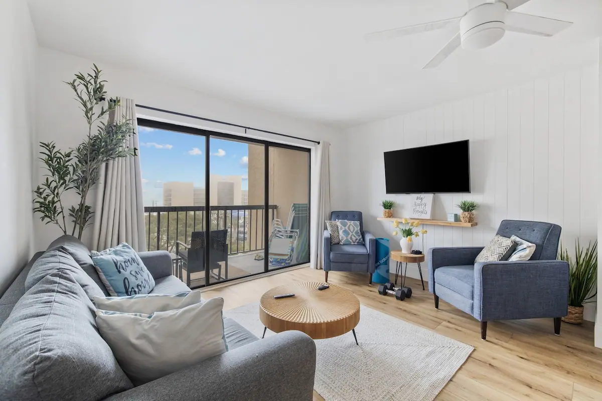 Living room with blue sofas and sliding glass balcony doors