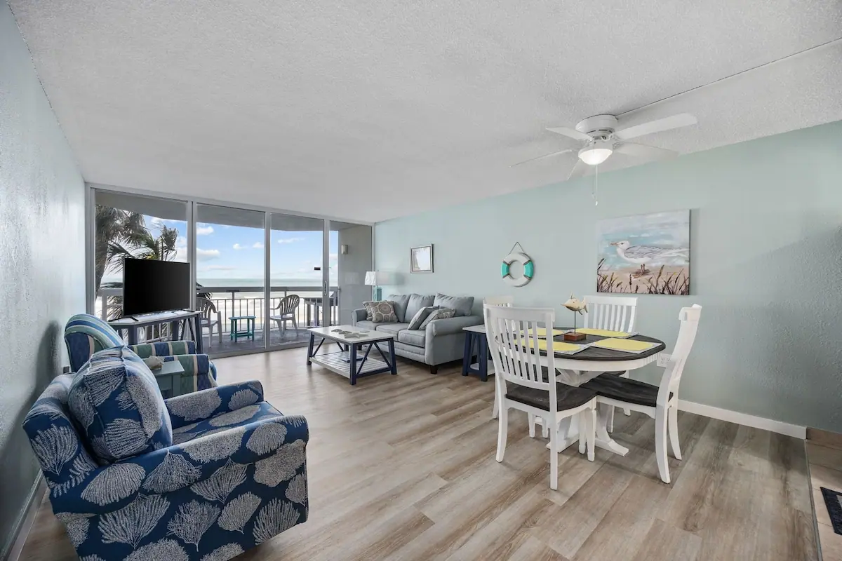 Living and dining room with large windows overlooking the ocean