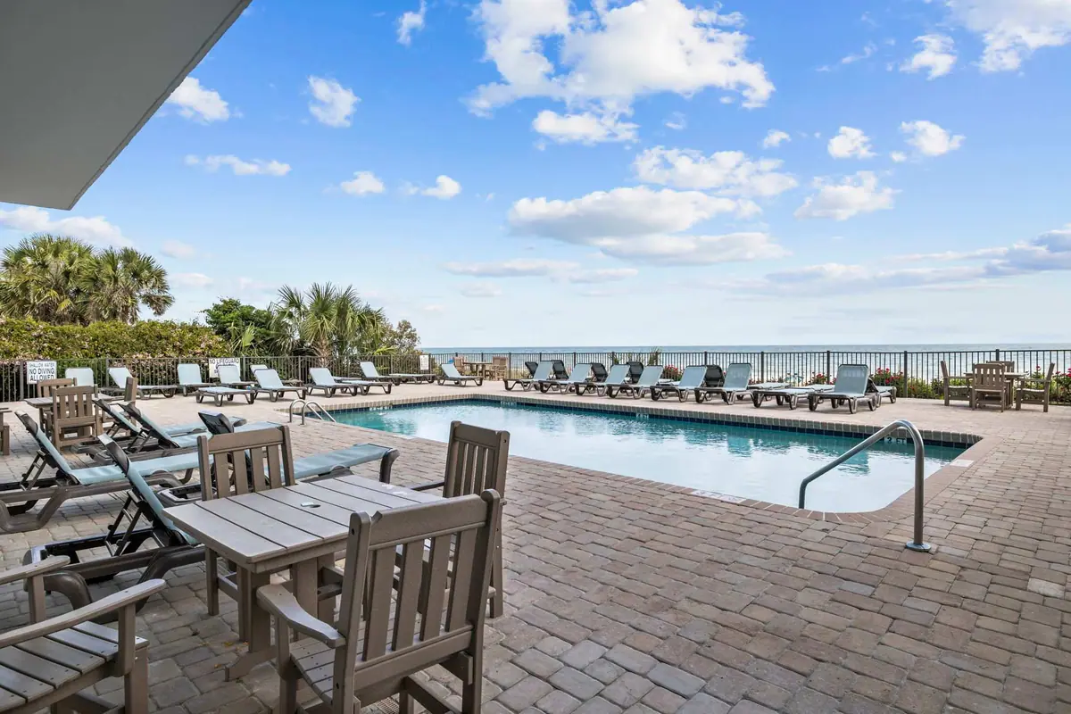 Outdoor pool and lounge chairs with the ocean beyond